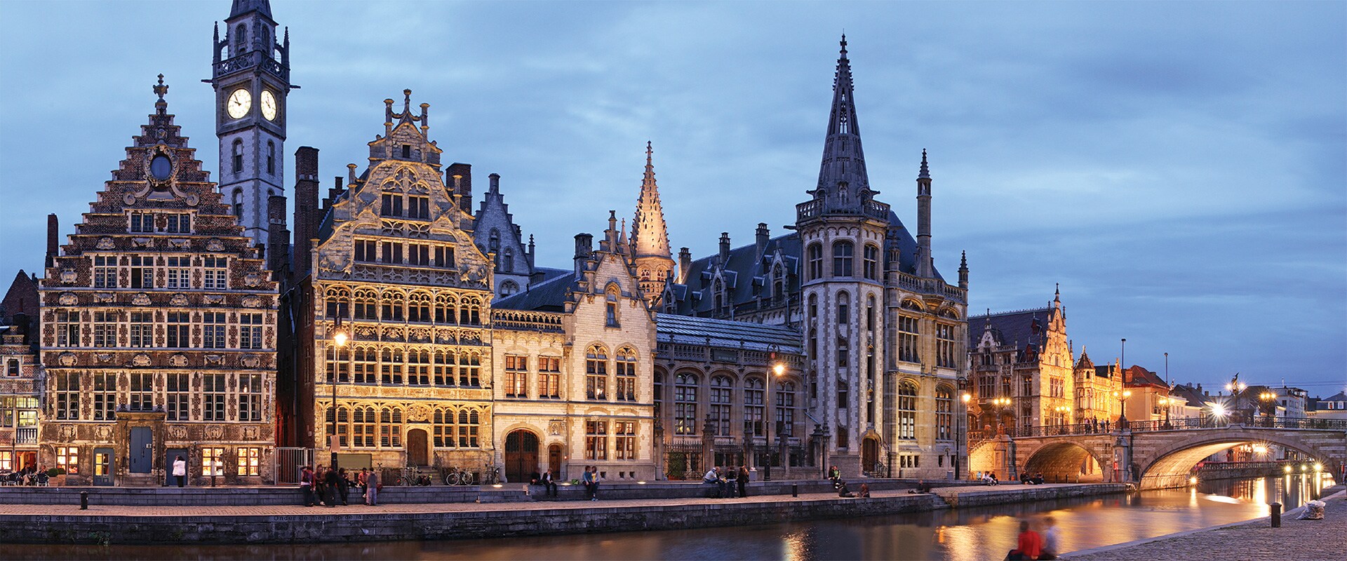 Ghent's medieval buildings along the channel, illuminated under the night sky