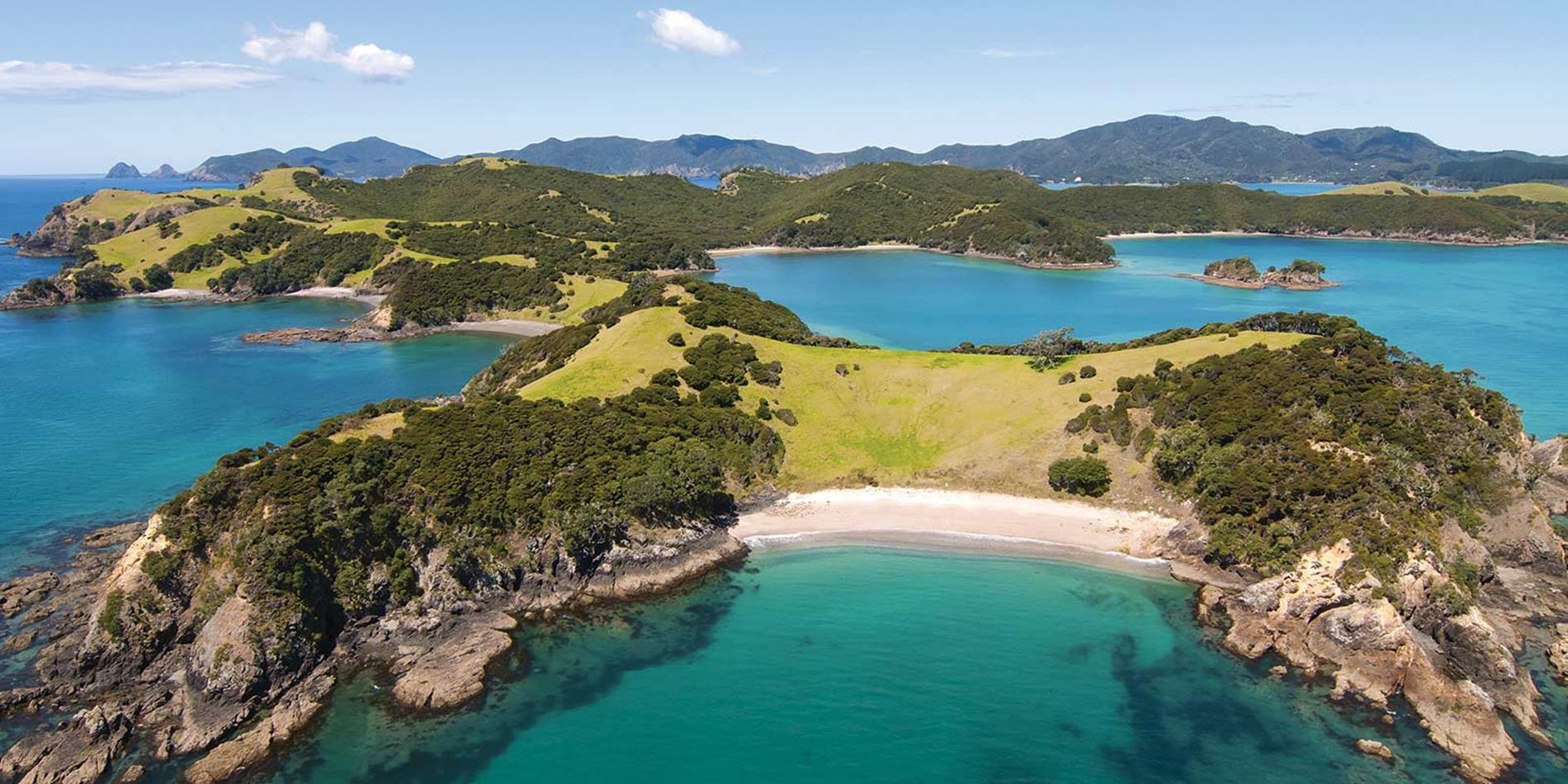 Aerial view across tranquil blue water and islands dotted along the coast, New Zealand